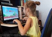 Девочка играет в Марио за компьютером
